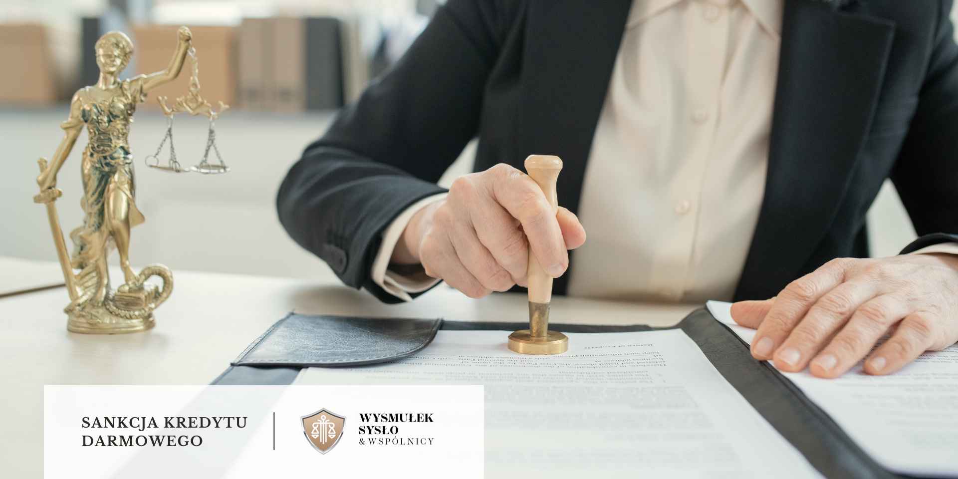 sankcja-kredytu-darmowego-pozew-sad <br />
Ręka osoby w czarnym garniturze stempluje dokument urzędową pieczęcią z drewnianą rączką, na biurku obok stoi złota statuetka Temidy z wagą